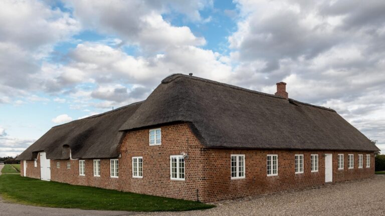 A large brick building with a thatched roof