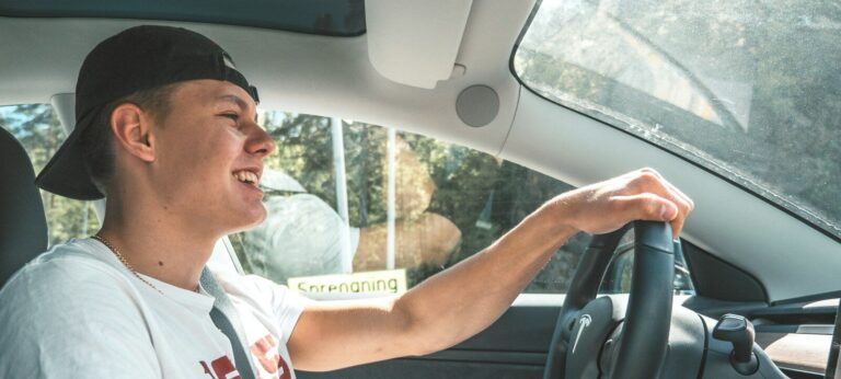 man in white crew neck t-shirt driving car